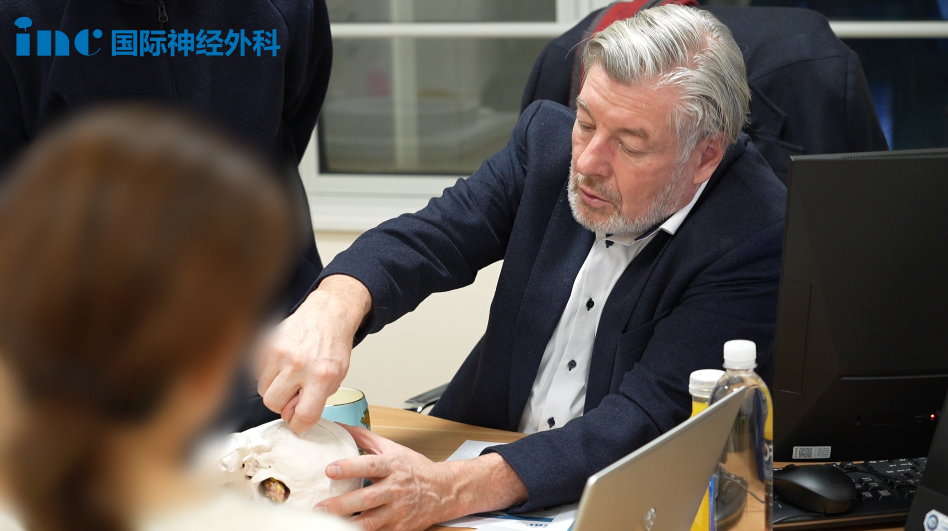 巴教授拿起手边的脑部模型为齐女士耐心讲解。
